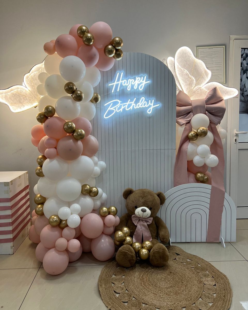 Roze, beli i zlatni baloni sa svetlećim natpisom Happy Birthday, svetlećim krilima i velikim medom