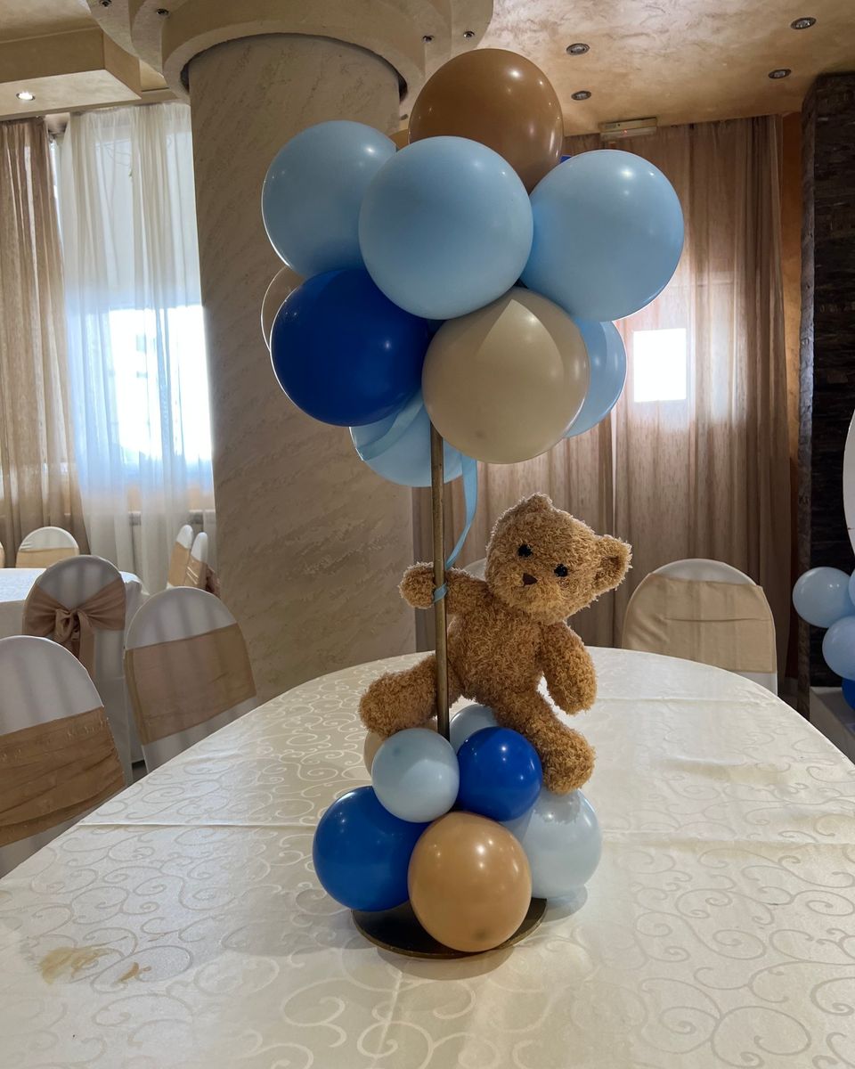 Plavi i bež baloni sa plišanim medom na stolu za dečiju proslavu