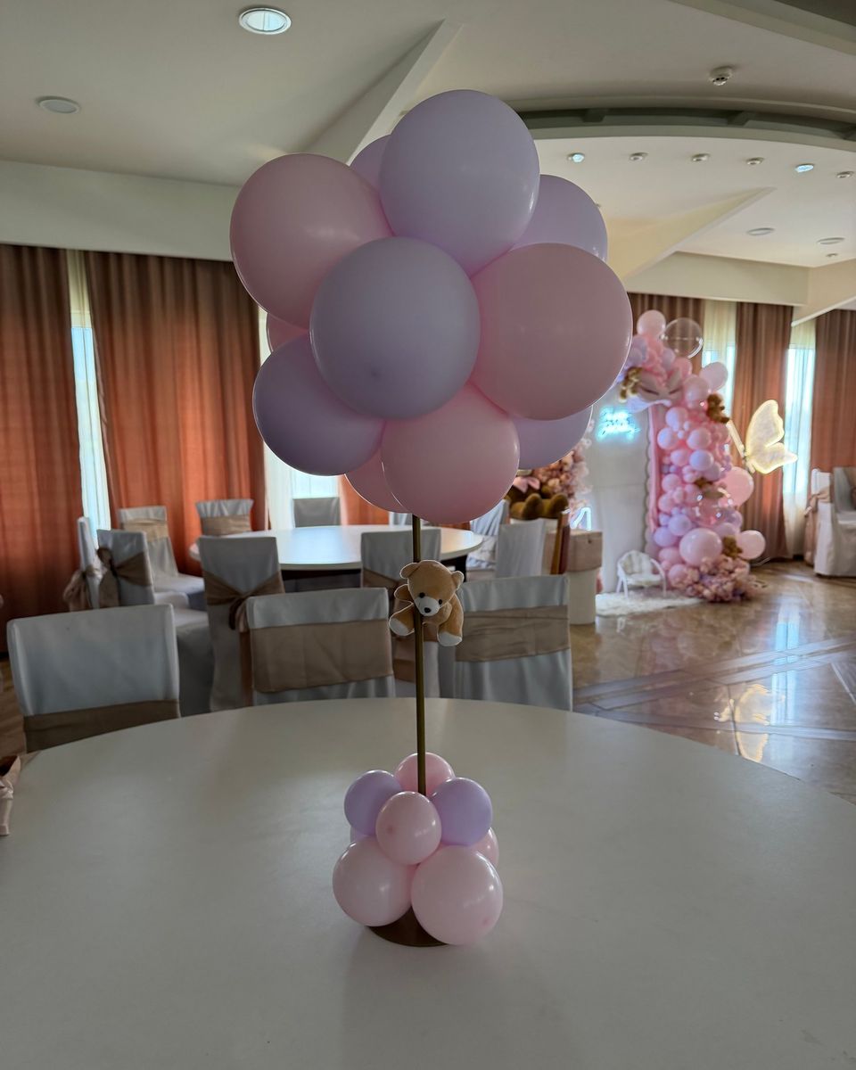 Roze i lila baloni sa malim plišanim medom na stolu za dečiju proslavu