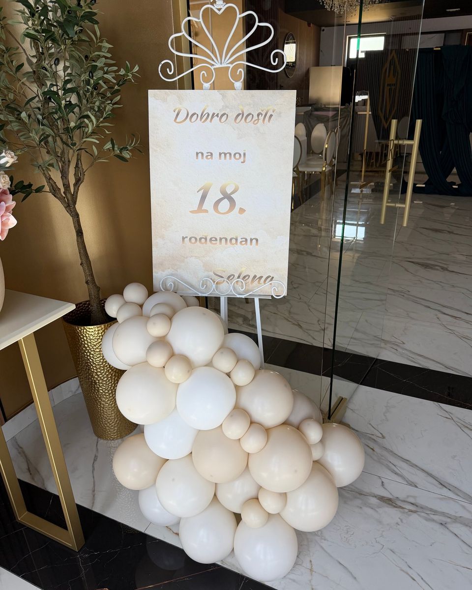 Tabla za 18. rođendan na belom stalku sa krunom i krem i belim balonima