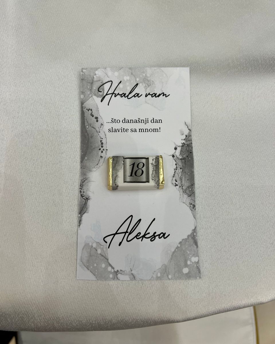 Siva zahvalnica Hvala vam sa čokoladicom sa brojem 18 na belom stolnjaku